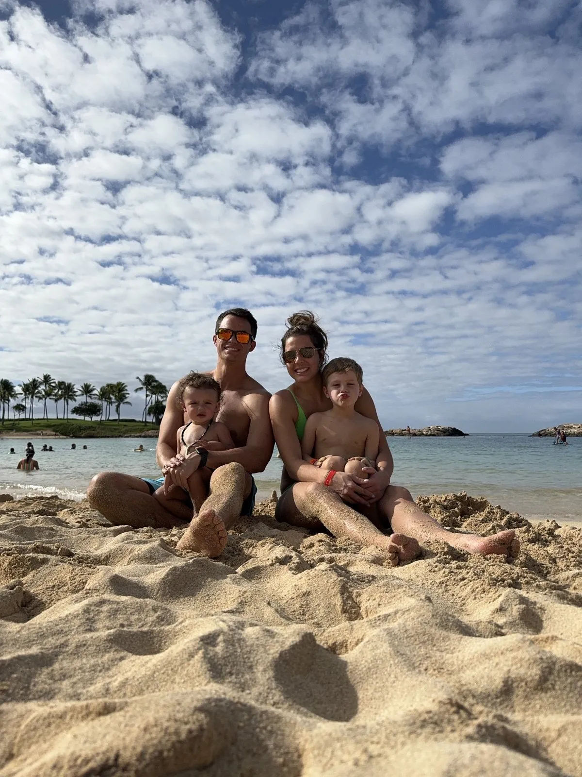 The family on a beach, the boys on their parents' laps