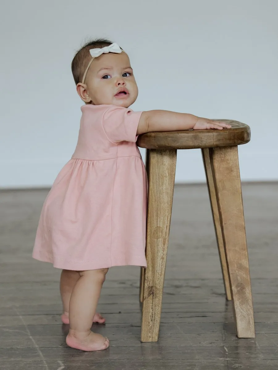 A child in the BRIN Penelope Dress, Rose, standing, from BRIN's launch photoshoot